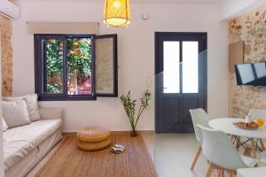 ein Wohnzimmer mit einem Sofa und einem Tisch in der Unterkunft Orestis downtown home in Rethymno