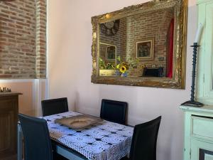 uma mesa com cadeiras e um espelho na parede em Luxury Apartments Casa Burraia em Abbadia di Montepulciano