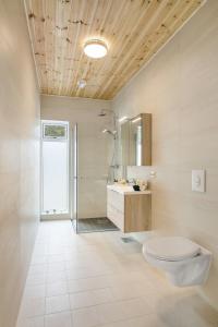uma casa de banho com um WC, um lavatório e um espelho. em House with fjord views Hommersåk ( stavanger, sandnes ) em Sandnes