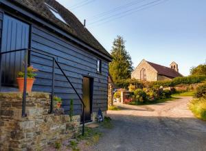 a blue barn with a door and a house at Little Drift in Edgton