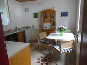 - une cuisine avec une table, des chaises et un évier dans l'établissement Ferienwohnung Maidenhain, 
