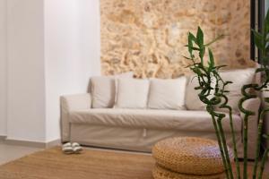 ein Wohnzimmer mit einer weißen Couch mit Kissen in der Unterkunft Orestis downtown home in Rethymno