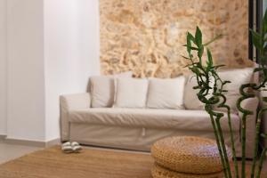 a living room with a white couch with pillows at Orestis downtown home in Rethymno Town +21 photos