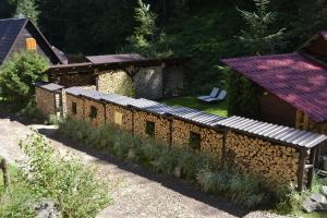un jardín con una pared de piedra y una casa en Casa "Cabana Varciorog Arieseni", en Arieşeni