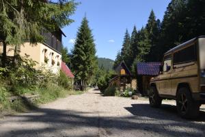 ein Fahrzeug, das auf einer unbefestigten Straße neben einem Haus parkt in der Unterkunft Casa "Cabana Varciorog Arieseni" in Arieşeni