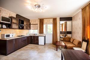 a kitchen with brown cabinets and a couch in a room at Tihaya Gavan in Kherson