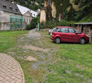 a red car parked in the grass in a yard at Hostel Skautský dom in Banská Štiavnica +37 photos