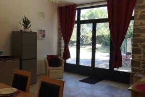 a living room with a large window with red curtains at Ruby - Gîte 2 chambres dans vieux prieuré près de Carcassonne in Sainte-Eulalie +18 photos