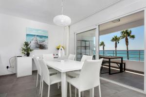 een eetkamer met een witte tafel en witte stoelen bij Luna Beach in Cabopino