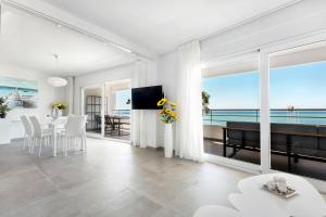 een witte woonkamer met uitzicht op de oceaan bij Luna Beach in Cabopino