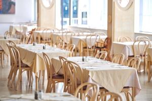 a row of tables and chairs in a restaurant at Hotel Istra Plava Laguna in Poreč