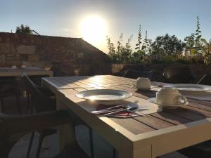 una mesa de madera con platos y utensilios. en Hotel-Restaurant Zum Onkel Jonathan en Raeren