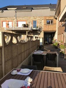 d'une terrasse avec des tables et des chaises ainsi que d'un balcon. dans l'établissement Hotel-Restaurant Zum Onkel Jonathan, à Raeren