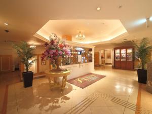 a lobby with a vase of flowers on a table at Hotel Fine Garden Kyoto Minami in Kyoto