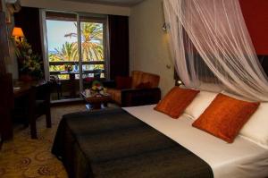 a hotel room with a bed and a chair and a window at Hotel Jardin Savana Dakar in Dakar