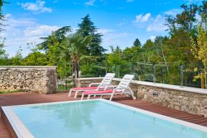 a patio with two chairs and a swimming pool at Hotel Mediteran Plava Laguna in Poreč
