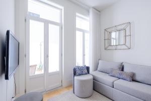 uma sala de estar com um sofá e um espelho em BOUTIQUE Rentals-Flores Terrace historical centre no Porto