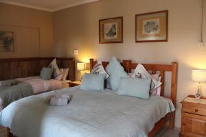 a bedroom with two beds with pillows at Honey Lodge in Klipdrift