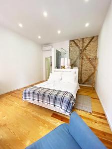 1 dormitorio con 1 cama grande y suelo de madera en The Postcard Lisbon, en Lisboa