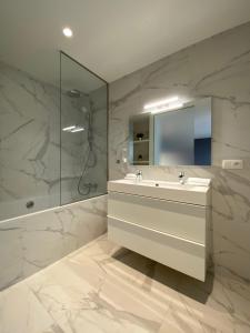 a bathroom with a sink and a shower and a mirror at Smartflats - Fashion in Brussels
