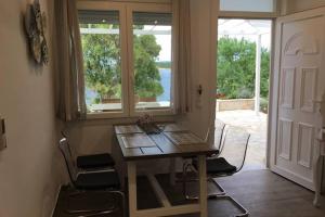 une table et des chaises dans une pièce avec une fenêtre dans l'établissement Corfu island KASSIOPI’S best sea view apartment, à Kassiopi 14 autres photos