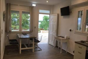 - une cuisine avec une table, un bureau et une table dans l'établissement Corfu island KASSIOPI’S best sea view apartment, à Kassiopi