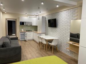 a kitchen and living room with a table and chairs at Magic Days Apartments in Chernihiv