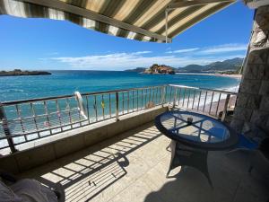 a bench sitting on a balcony overlooking the ocean at Apartments Lungo Mare in Sveti Stefan