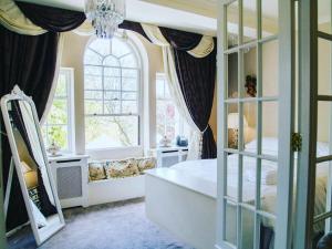 a bedroom with a bed and a large window at WILDES INNs in Chesterfield