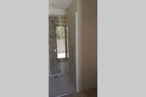 a shower with a glass door in a bathroom at Diamond - Gîte dans vieux prieuré près de Carcassonne in Sainte-Eulalie