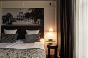 a bedroom with a bed and a lamp at Ascot Hotel in Copenhagen