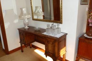 a table with a mirror and some vases on it at Willow Cottage in North Lydbury +59 photos