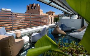 a balcony with pillows and chairs on a roof at Azzoli Trapani - Apartments&Skypool - Adults Only in Trapani
