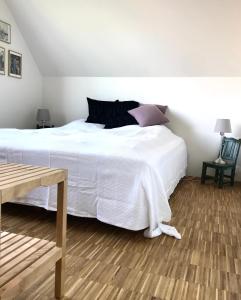 sypialnia z dużym białym łóżkiem i drewnianą podłogą w obiekcie Villa Stjerneklar w Kopenhadze