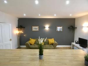 uma sala de estar com um sofá verde e almofadas amarelas em Westbourne Villas em Bristol