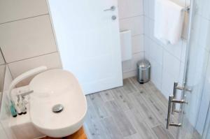 a white bathroom with a toilet and a shower at Chandos Apartments in Broadstairs