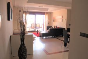 ein Wohnzimmer mit einer Vase in der Mitte des Zimmers in der Unterkunft El Soto de Marbella FREE Golf-Tennis-Spa Area 2 Bedroom Penthouse in La Mairena
