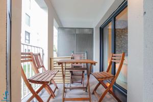 a balcony with a wooden table and chairs at Appart avec Parking Climatisation Loggia à la Cité du Vin in Bordeaux