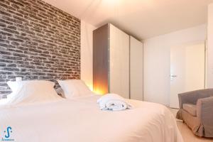 波爾多的住宿－Appart avec Parking Climatisation Loggia à la Cité du Vin，卧室配有白色的砖墙床