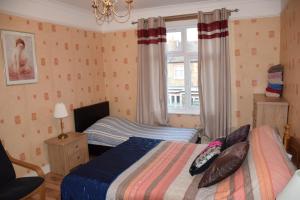 a bedroom with two beds and a window at Three Bedroom Flat, Camborne Avenue W13 in London