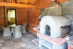 un horno de leña en una cabaña con mesa en Chalet le Bruleux, en La Bresse