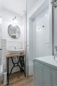 La salle de bains est pourvue d'un lavabo et d'un miroir. dans l'établissement Murano Art Home, à Varsovie