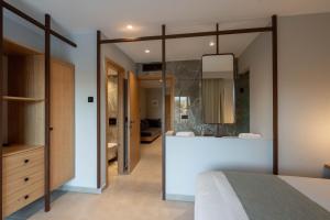 a bedroom with a large mirror and a bathroom at Stella Palace Aqua Park Resort in Hersonissos