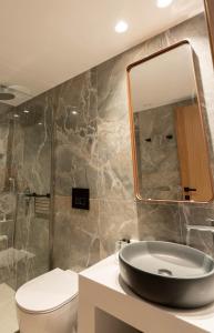 a bathroom with a sink and a toilet and a mirror at Stella Palace Aqua Park Resort in Hersonissos