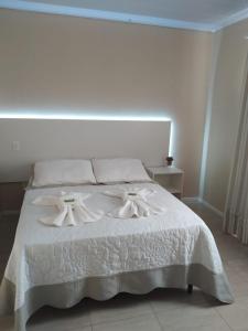 sypialnia z białym łóżkiem z białą pościelą w obiekcie Casa Karina w mieście Urubici