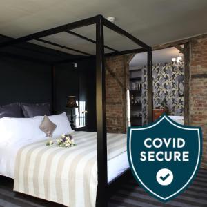 1 dormitorio con 1 cama con un cartel de servicio de corcho en The Crown And Thistle en Abingdon