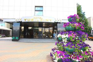 un'esposizione di fiori di fronte a un edificio di Hotel Yubileiny a Minsk