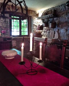 Faedis的住宿－TORRE DEL GRIFONE nel medioevo di Cividale del Friuli，一间房间,桌子上放着三根蜡烛