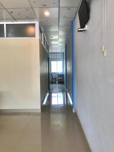 un corridoio di un edificio adibito a uffici con tavolo e sedie di Tanarod Gueshouse a Suratthani