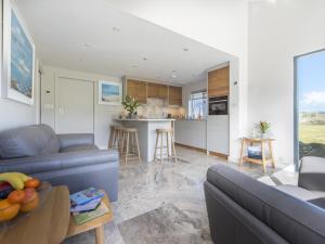 a living room with a blue couch and a kitchen at chyreen@marazion in Marazion